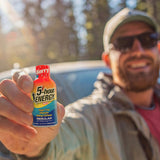 Man holding a 5-hour ENERGY drink bottle outdoors