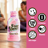 A bottle of 5-hour Energy Cotton Candy caffeine drink on a wooden table with a pink graphic panel on the right showing product benefits like 'Tasty', '230 mg Caffeine', '0 Calories', 'Zero Sugar', and 'No Fat'.