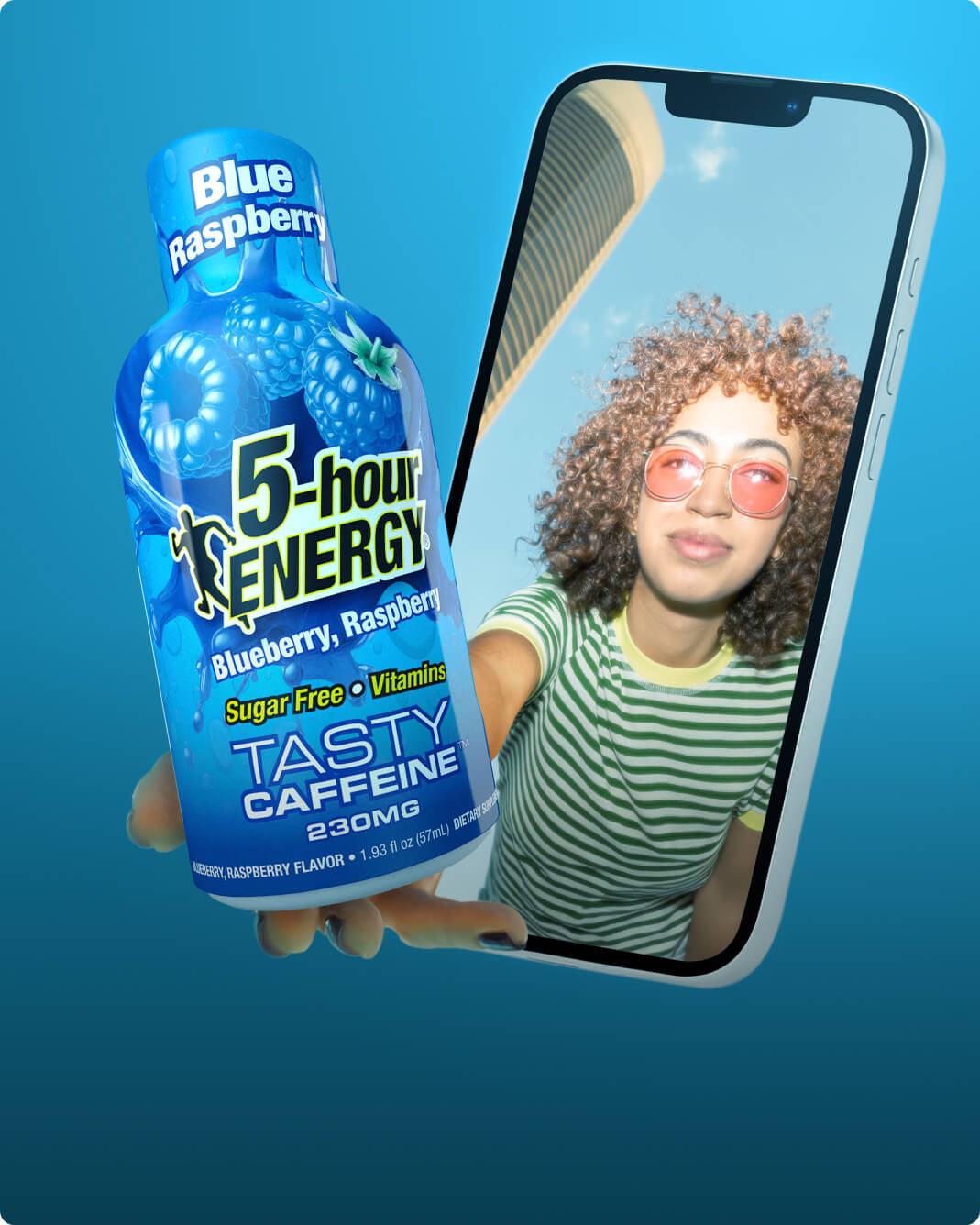 A bottle of 5-hour Energy Blue Raspberry flavored caffeine drink is held in front of a smartphone screen showing a woman taking a selfie, set against a solid blue gradient background.