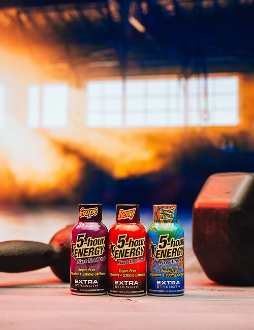 Three bottles of 5-hour Energy drinks on a table with a blurred background