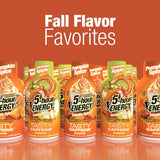 A promotional display of five 5-hour Energy Tasty Caffeine energy drink bottles in pumpkin spice and caramel apple flavors, arranged in a row against a solid orange background with the text 'Fall Flavor Favorites' at the top.