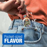 A close-up of a person's hand holding a miniature 5-hour Energy drink bottle tucked into the back pocket of light-wash blue jeans. White measurement lines indicate the bottle is 3.5