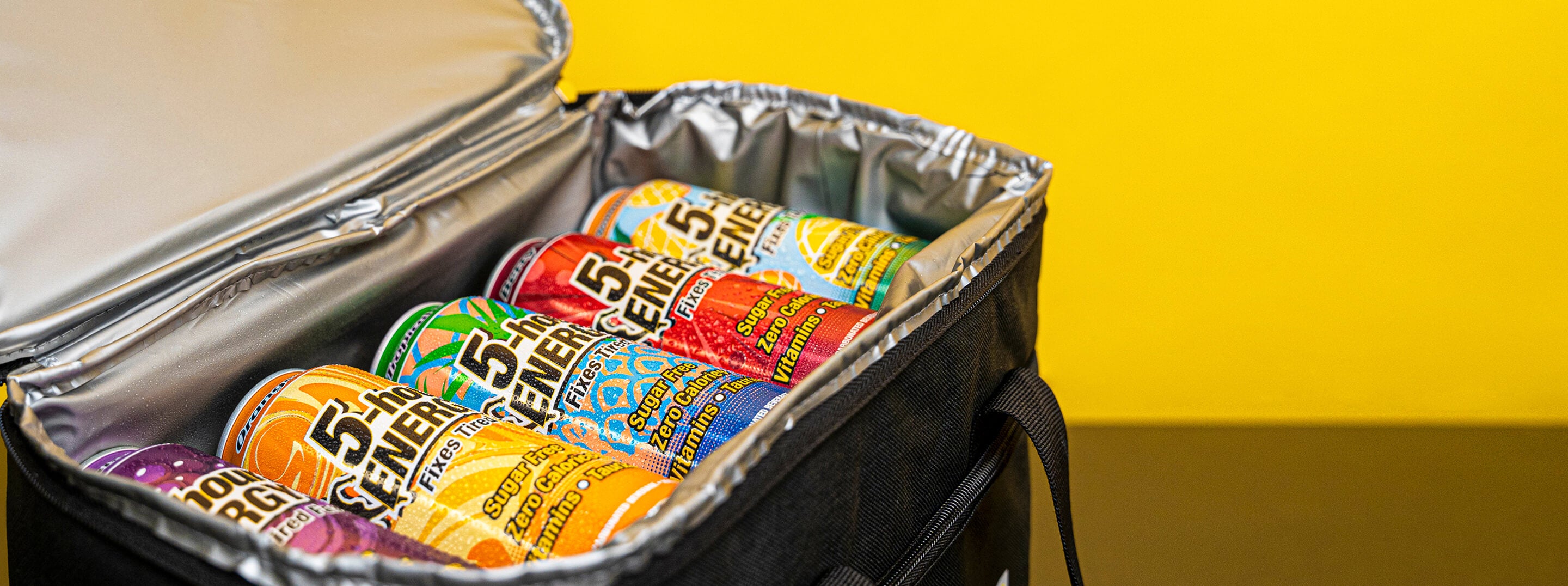 Insulated cooler bag with 5.10 beer cans against a yellow background