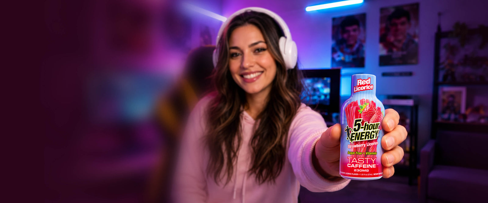 Woman holding a 5 Hour Energy drink in a room with colorful lighting